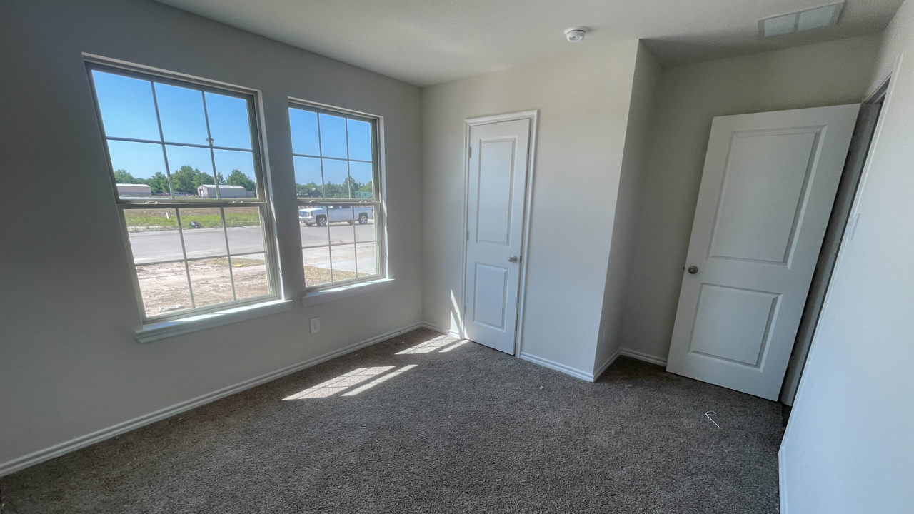 secondary bedroom with carpet and large window providing natural light