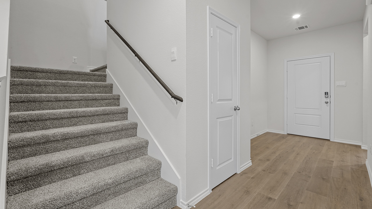 entry way with carpeted stairs leading to second floor