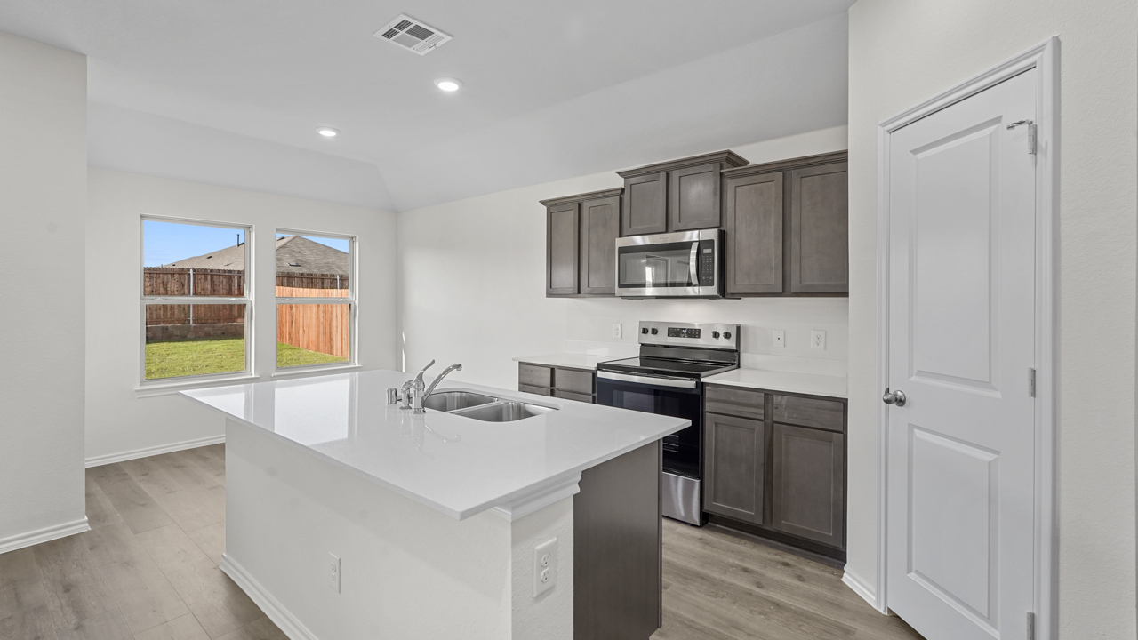 kitchen area with hardwood floors light colored counters and dark cabinets