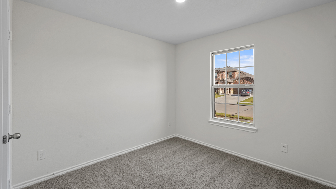 secondary bedroom with carpet and large window