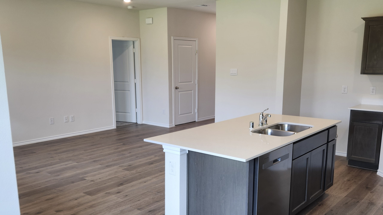 kitchen area with light colored counters and dark cabinets