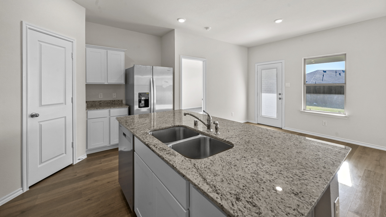 a kitchen with white cabinets an island in the middle and wood floors