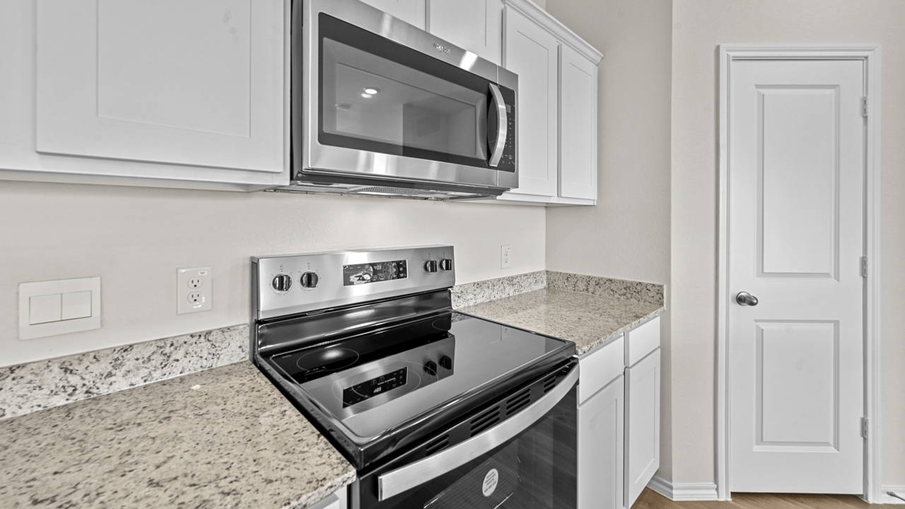 a kitchen with white cabinets an island in the middle and wood floors