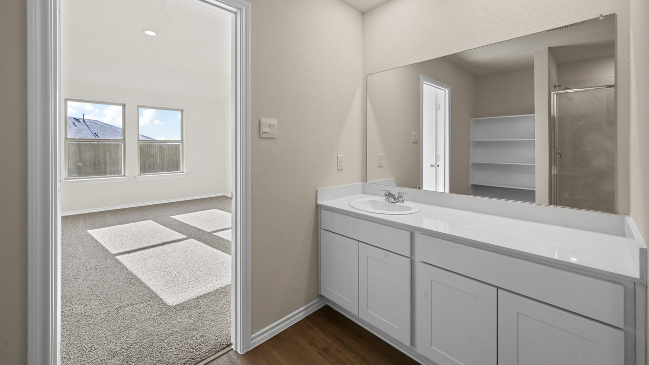 a bathroom with white cabinets and a mirror