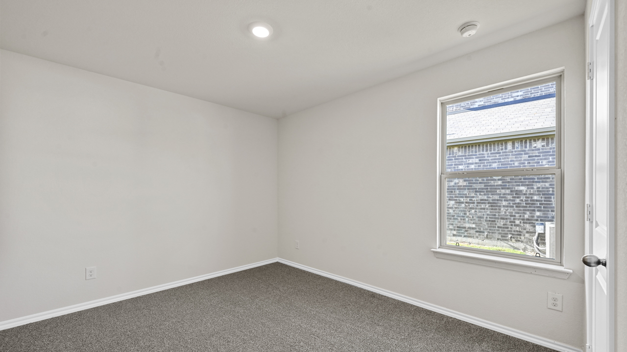 an empty bedroom with gray carpet and white walls