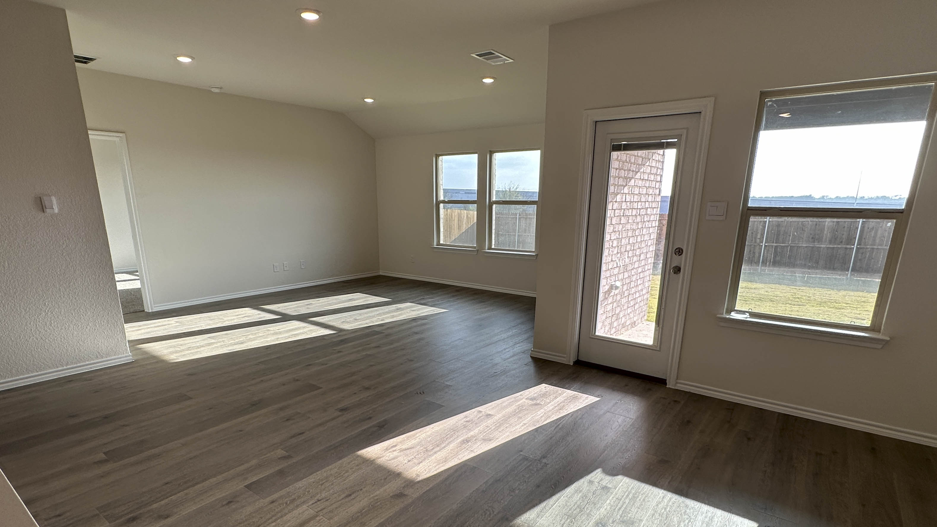 open concept living area with hardwood floors and large windows providing natural light