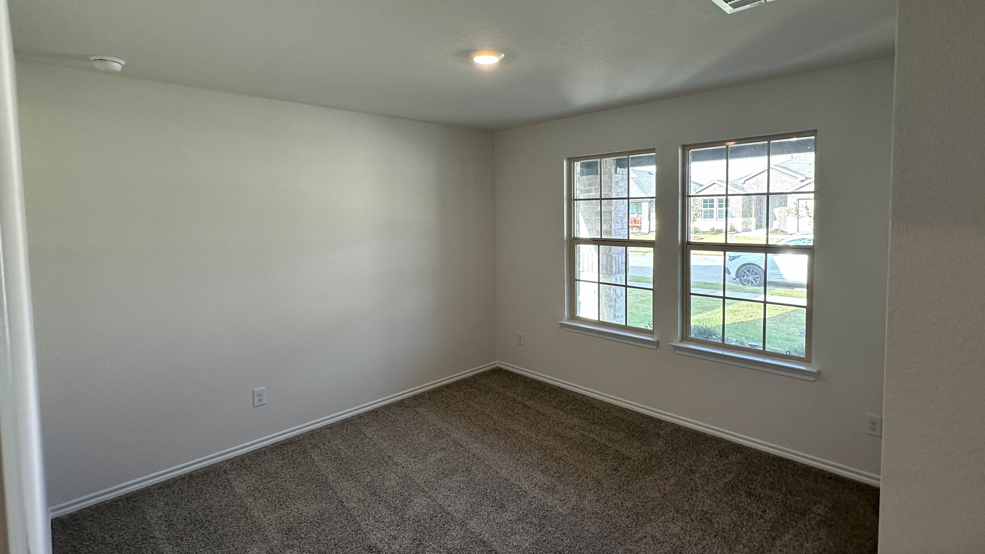 secondary bedroom with carpet and large windows providing natural light