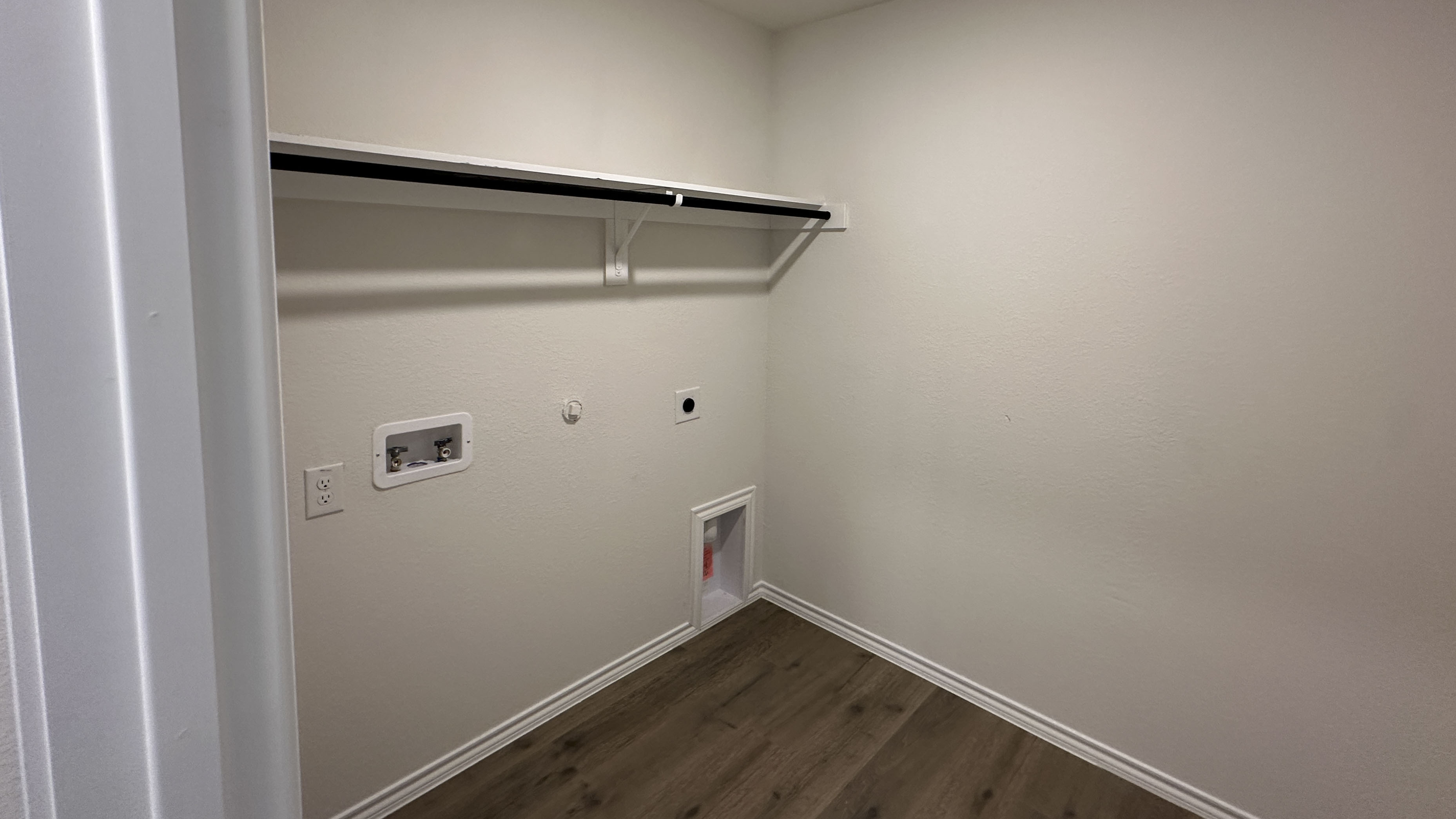 utility area with hardwood floors