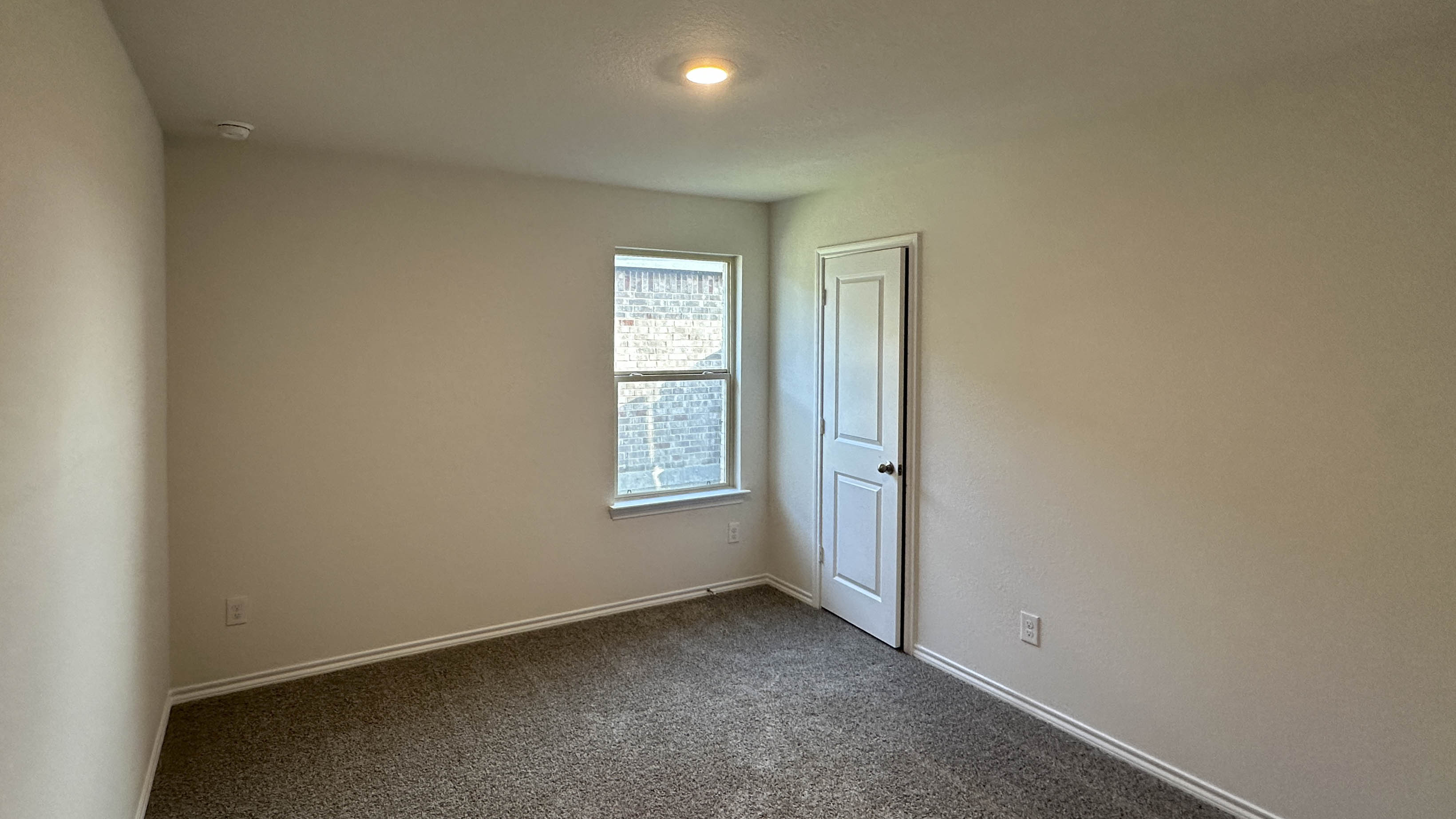 secondary bedroom with carpet and large windows providing natural light