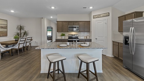 X40L kitchen area with granite counters and dark cabinets