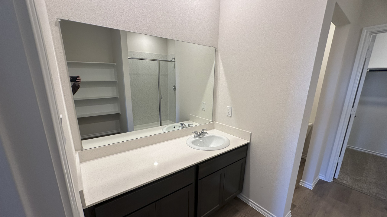 primary bathroom with white counters and dark cabinets