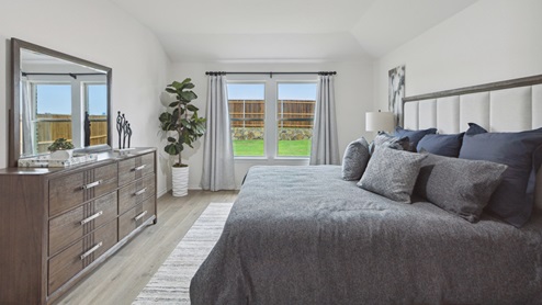 2106 Woodrose Court One-story model at Cartwright Ranch in Crandall, TX primary bedroom with hardwood floors and natural lighting