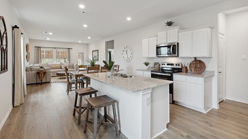 2110 Woodrose Court two-story model at Cartwright Ranch in Crandall, TX kitchen area with granite counters and white cabinets