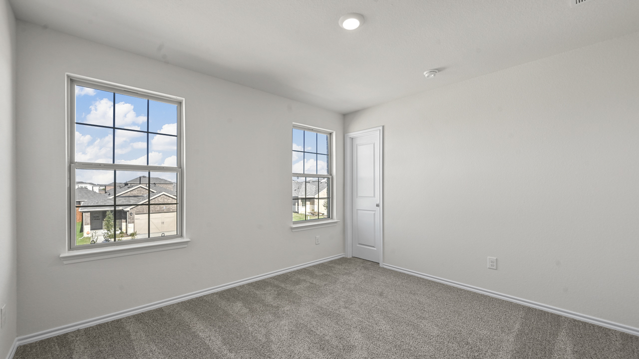 an empty bedroom with white walls and gray carpet