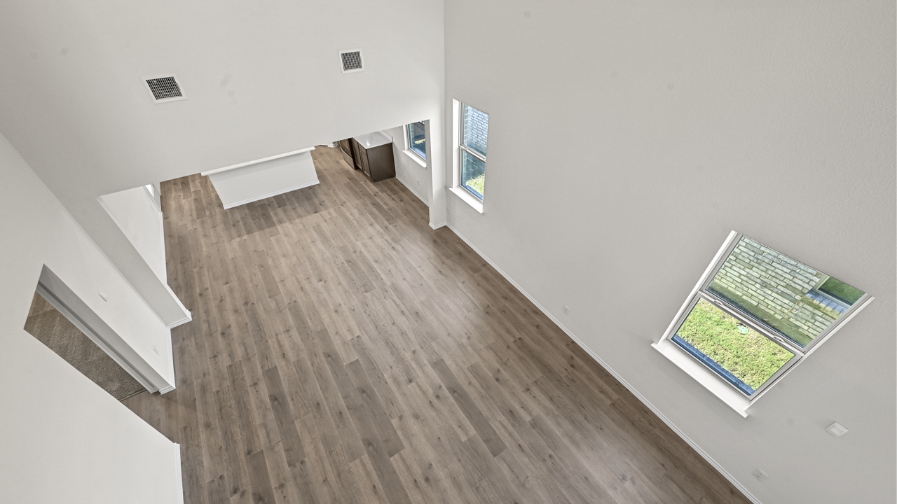 a view of the open living area from the stairwell with white walls and high ceilings