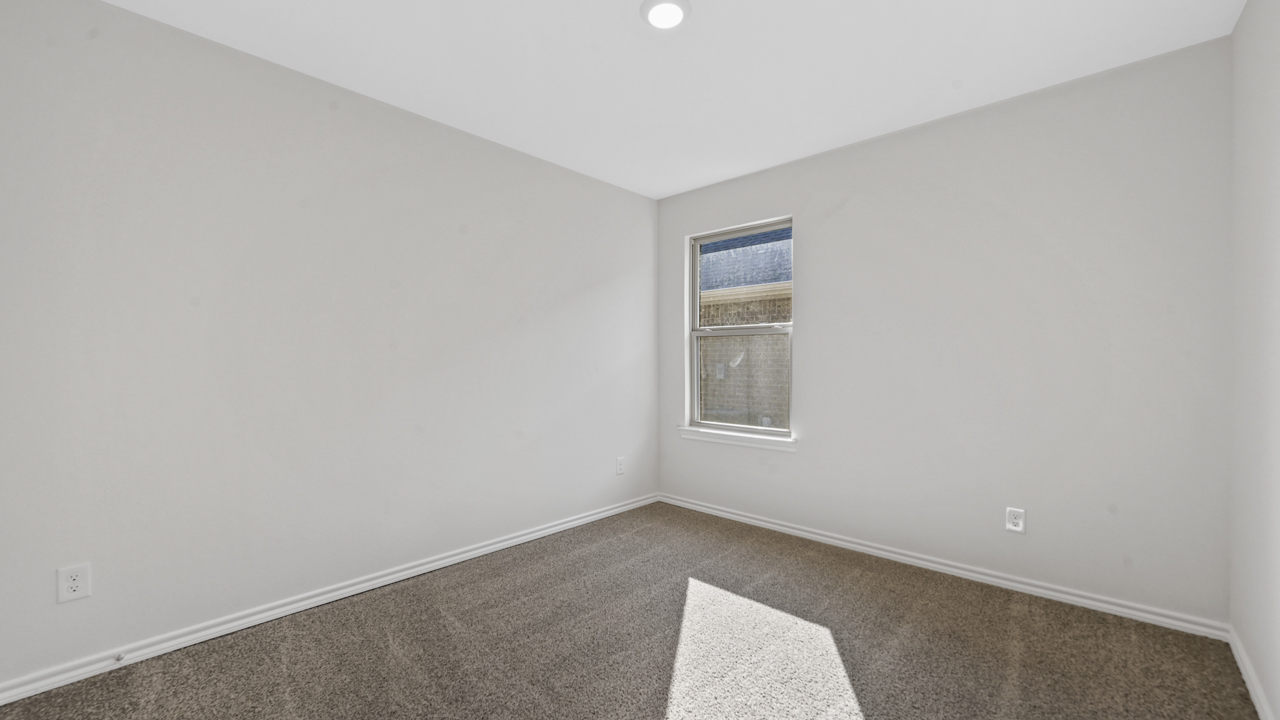 secondary bedroom with large window and carpet