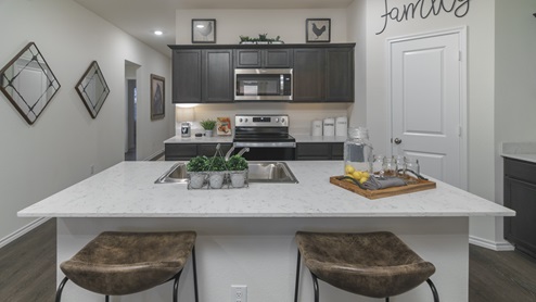2914 Drury Lane at Stonewyck Farms in Ennis, TX kitchen area with white counters and dark cabinets