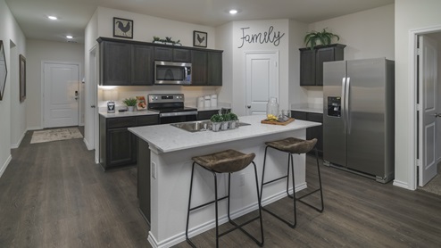 2914 Drury Lane at Stonewyck Farms in Ennis, TX kitchen area with white counters and dark cabinets