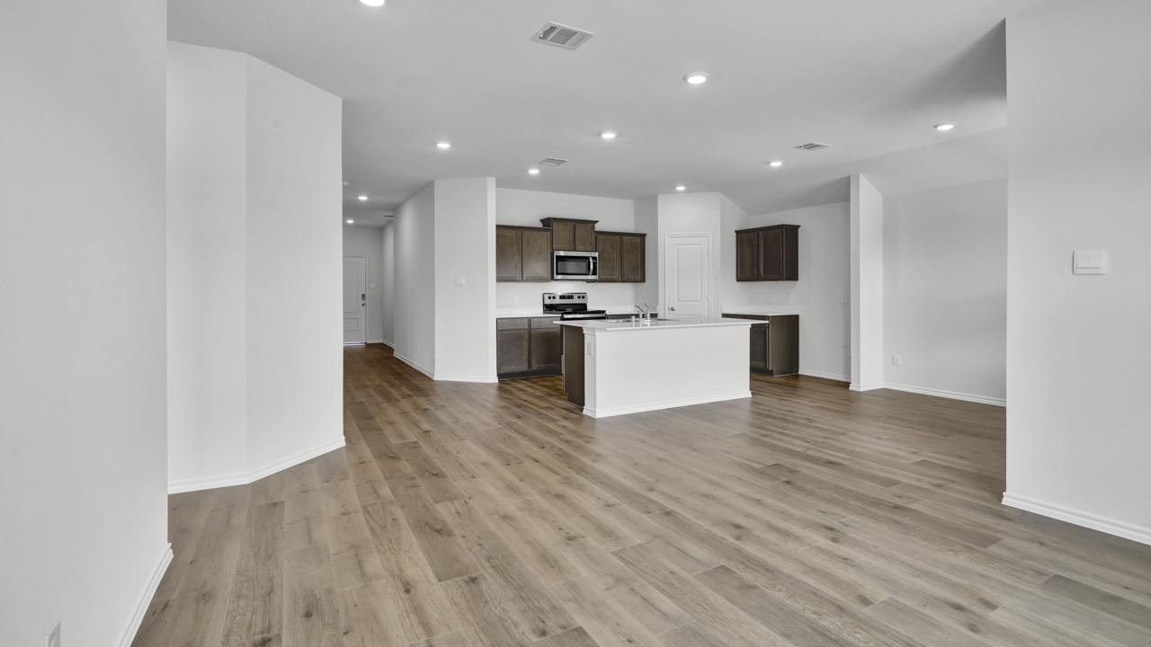 Open concept living area with hardwood floors and large windows providing natural light to the living space