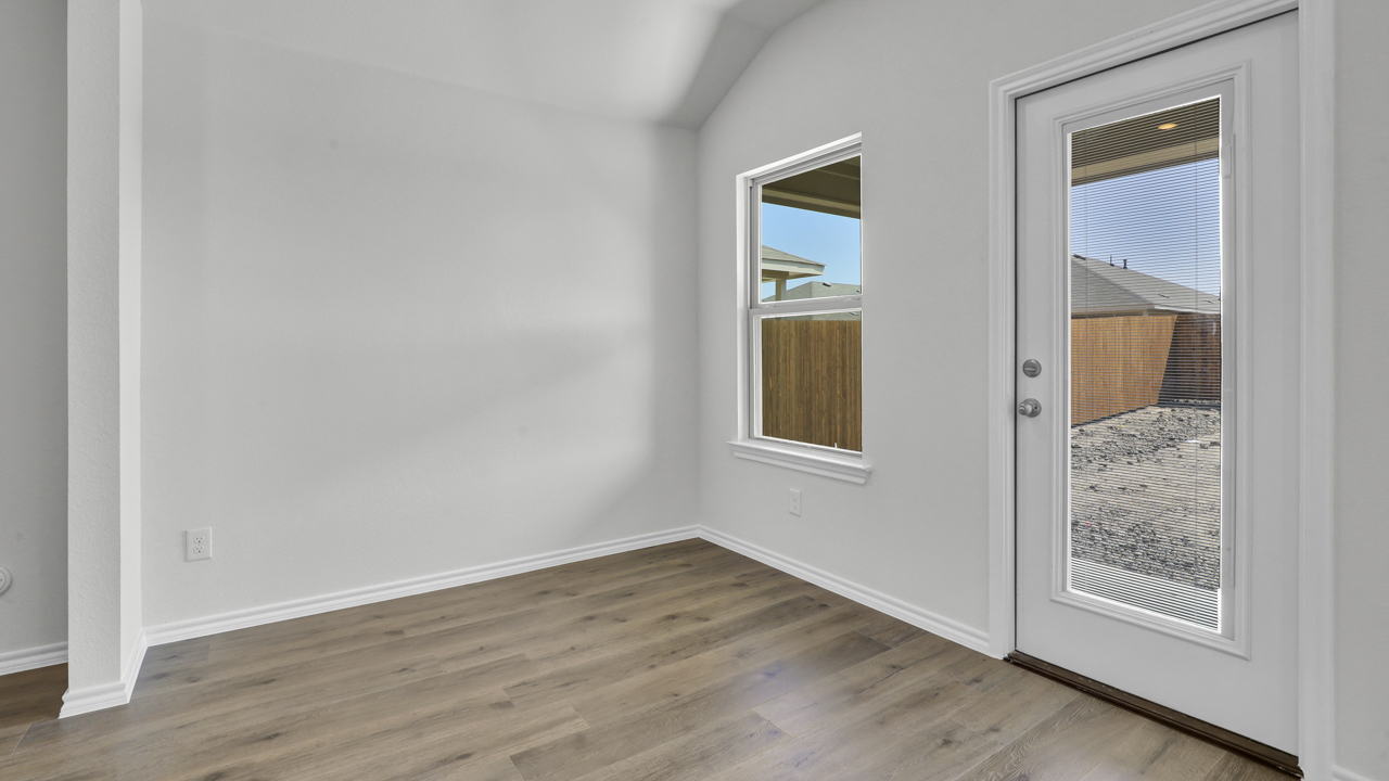 Dining area with hardwood floors and large windows facing the backyard and patio