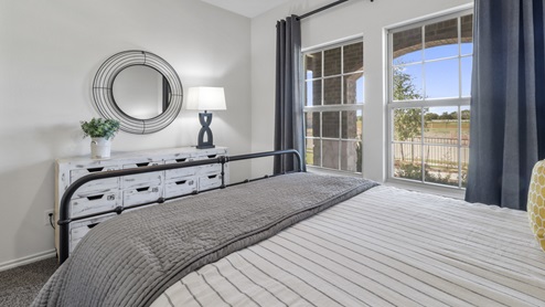 Furnished bedroom with two windows and closet