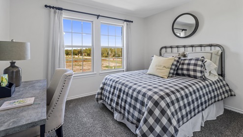 Furnished bedroom with two windows and closet