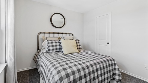 Furnished bedroom with two windows and closet