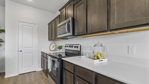 Long kitchen counter and brown cabinets with stainless steel appliances