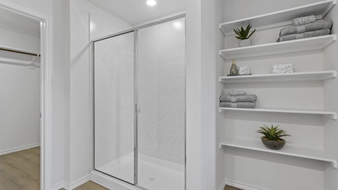 Primary bathroom with stand up shower and shelves for storage