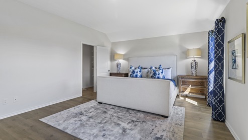 Large primary bedroom with windows and views into primary bathroom