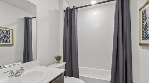 Secondary bathroom with garden tub and white countertop vanity