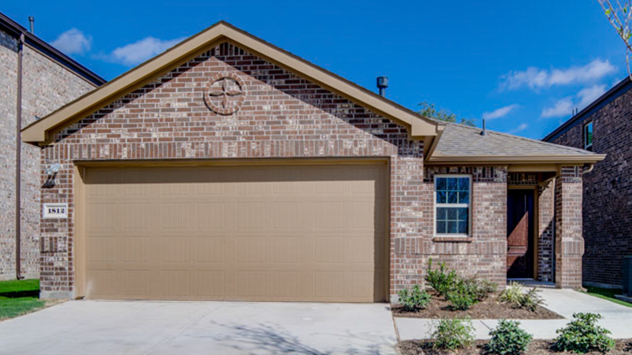 exterior of one story home with brick exterior left front entry to the home with two car garage and driveway