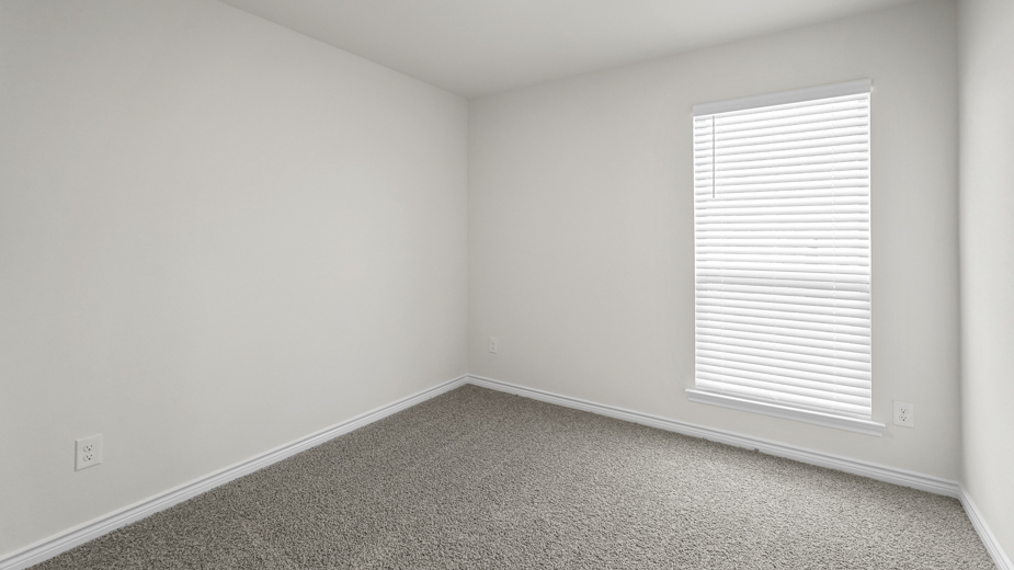 secondary bedroom with carpet and large window providing natural light