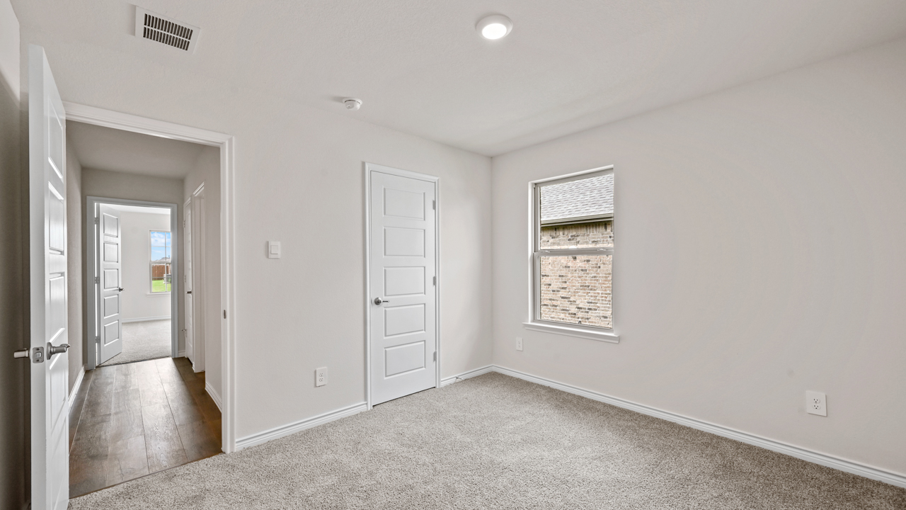 open bedroom with a window and grey carpet