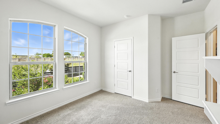 bedroom with beige carpet, white walls and two windows