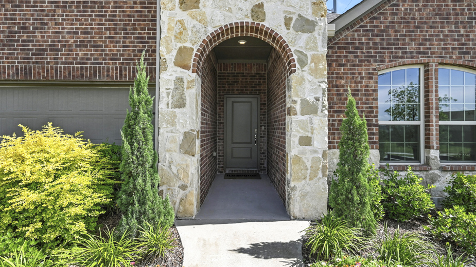 front exterior of a home with brick and stone exterior and a two car garage
