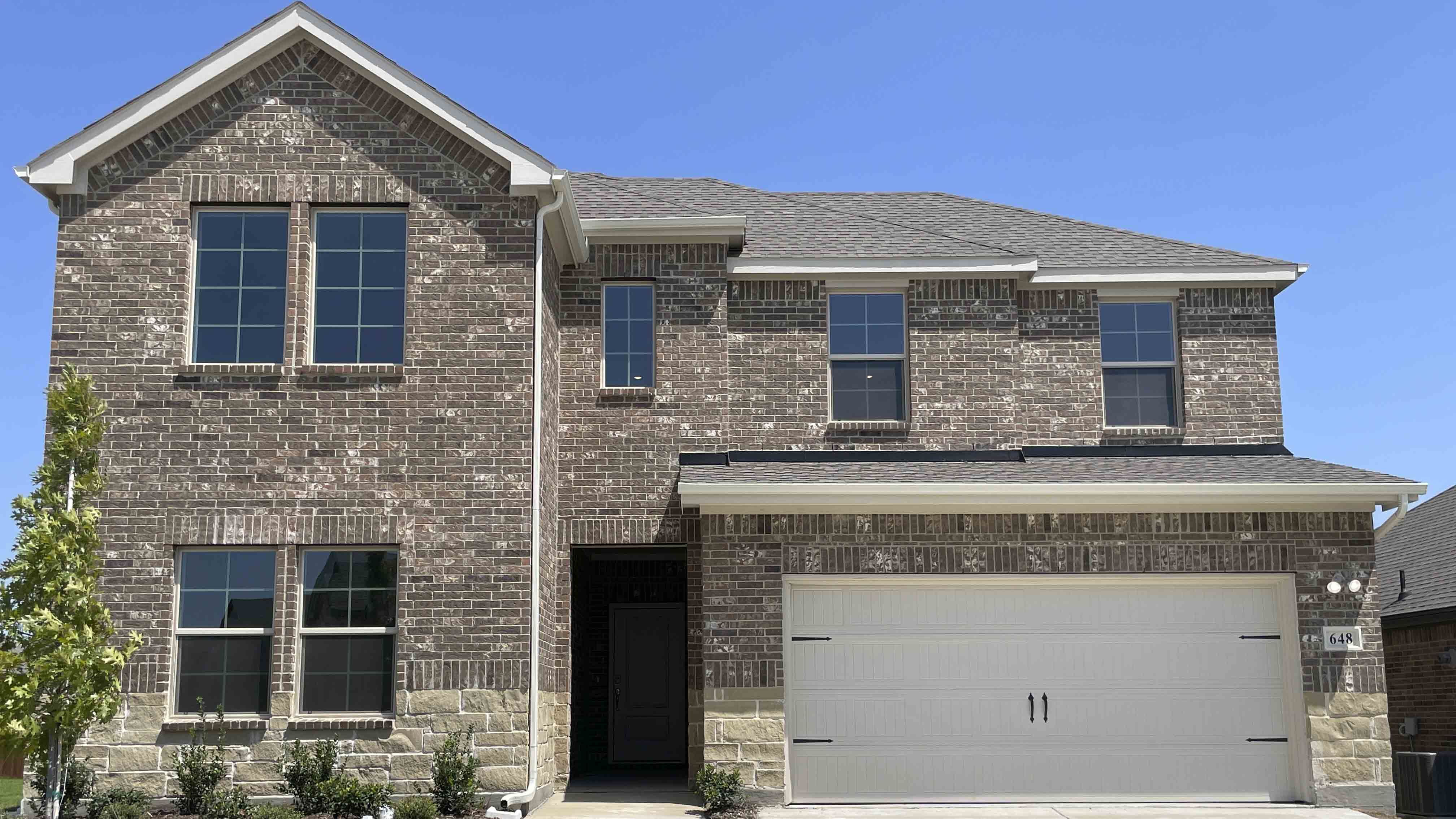 exterior of two story home with brick and stone exterior
