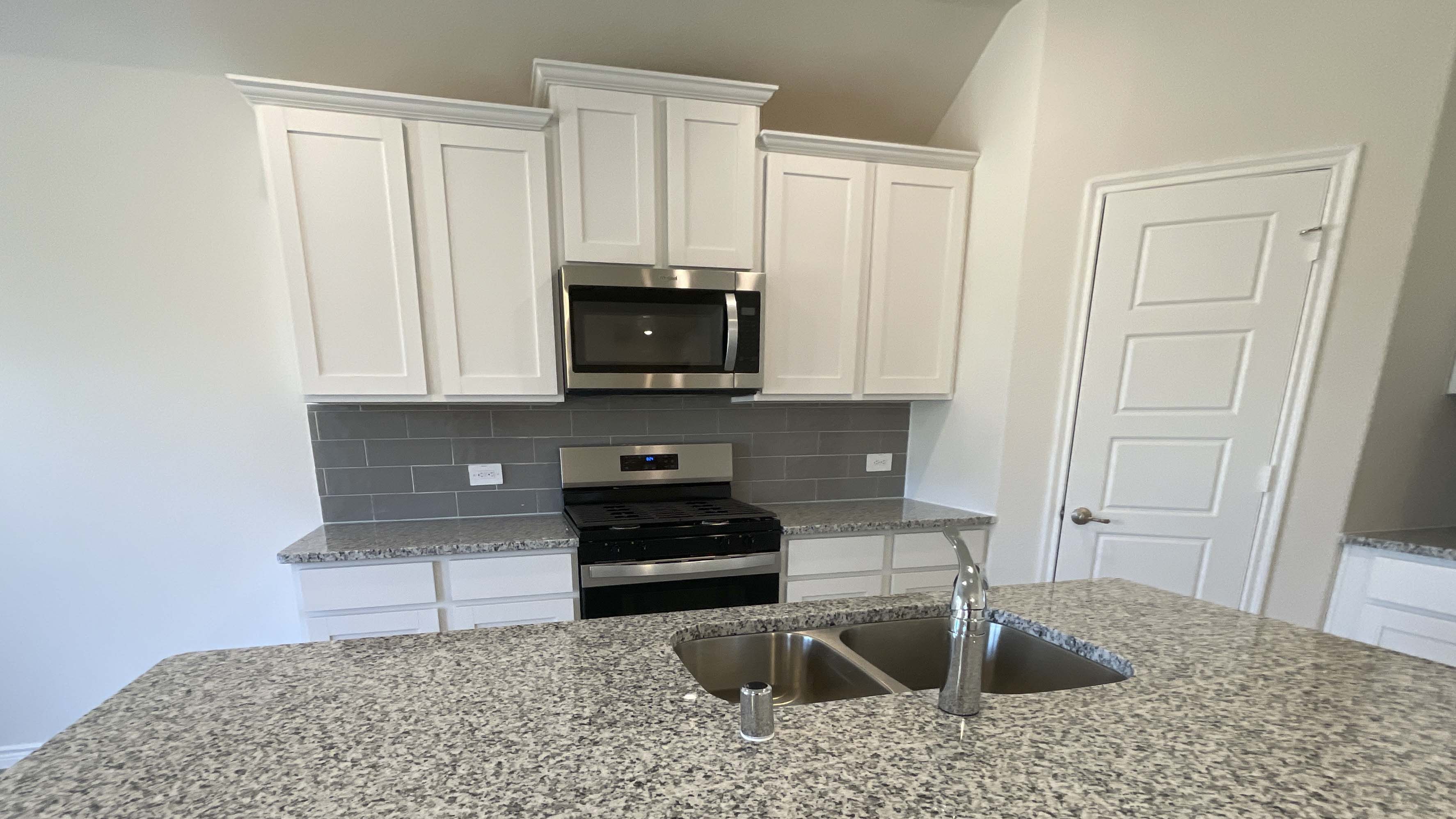 kitchen area with granite counters and white cabinets