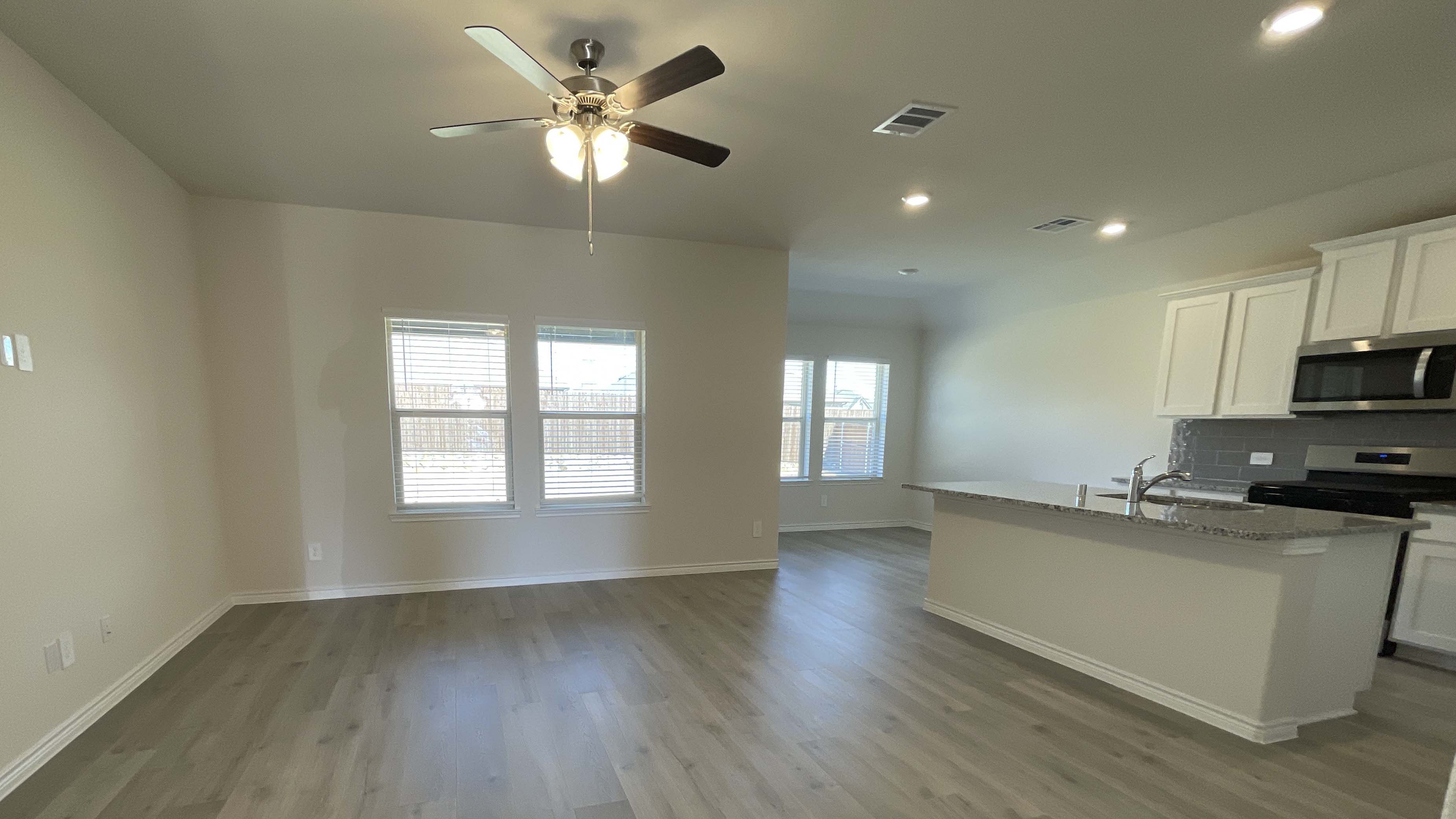 open concept living area with hardwood floors and large windows facing the backyard