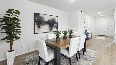 Dining area with table, chairs, and natural lighting.