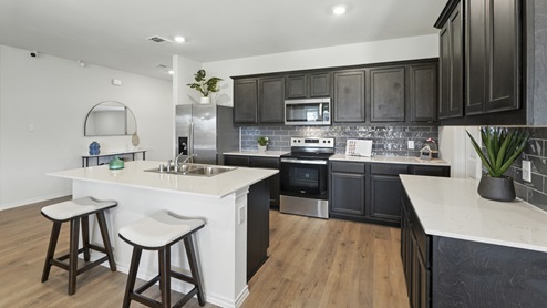 Kitchen featuring cabinets, new stainless steel appliances, and a large standing island.