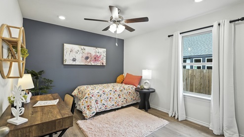 Carpeted bedroom with simple decor and natural lighting.