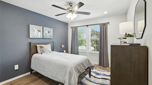 Bedroom with neutral walls, furnishings, and a window.