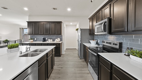 kitchen with brown cabinets white counters and blue blacksplash