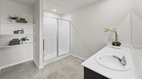 large primary bathroom with stand up shower and storage shelves