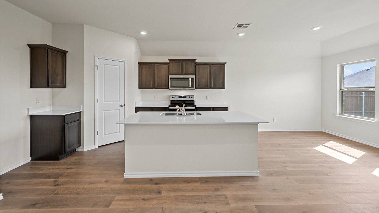 a kitchen with dark cabinets