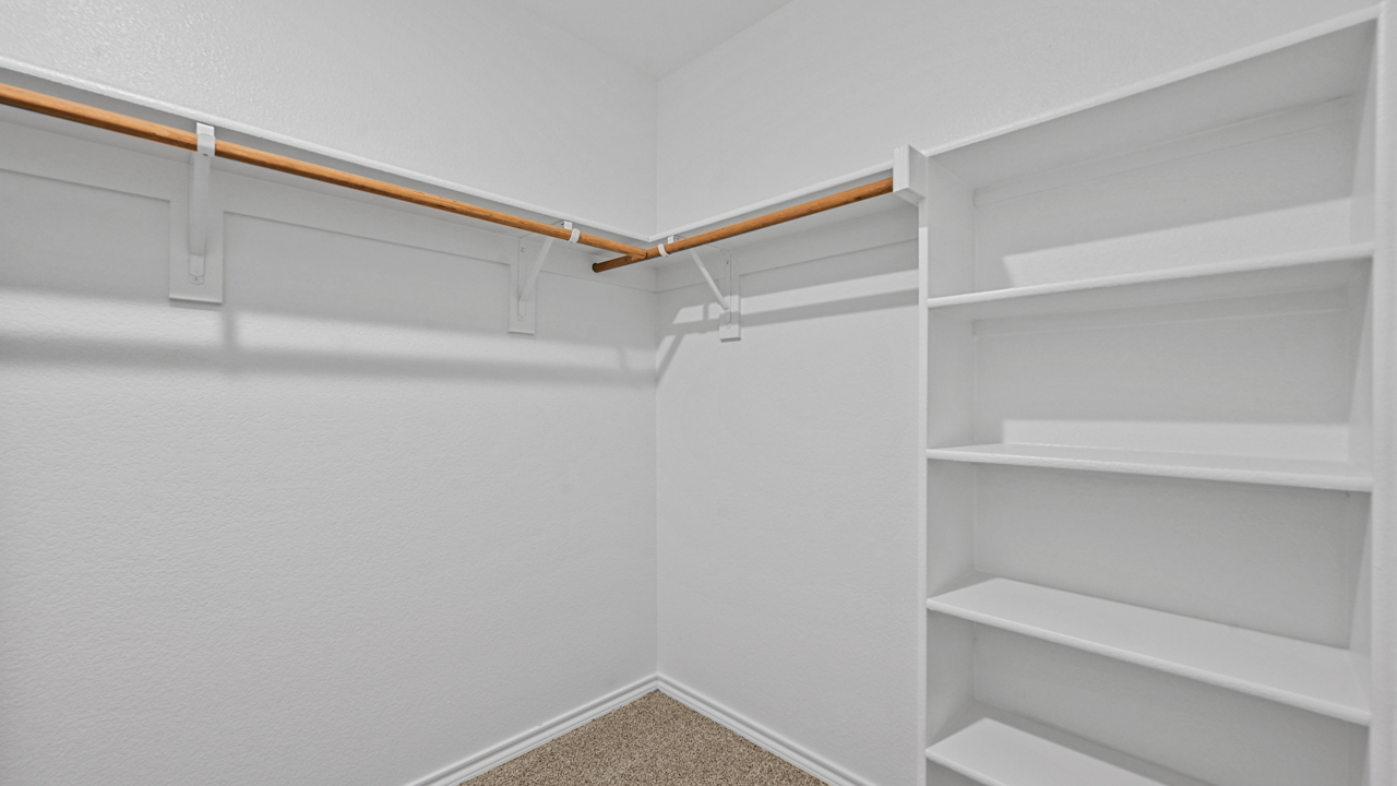 a walk in closet with built in shelves