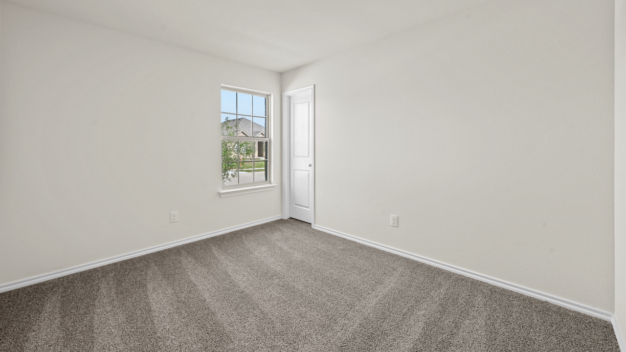an empty bedroom with gray carpet