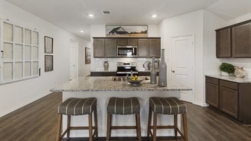 X40I kitchen area with granite countertops and dark cabinets