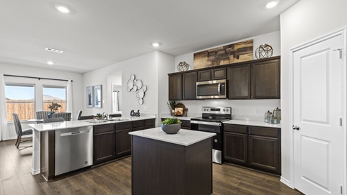 X40T kitchen area with granite countertops and dark cabinets
